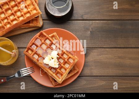 Plate of delicious Belgian waffles with honey and butter served on wooden table, flat lay. Space for text Stock Photo