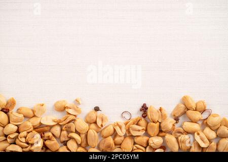 Spicy flavored peanut kernel spilling on white table background. Stock Photo