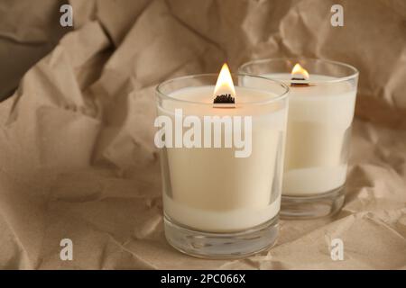Burning candle with wooden wick on grey table Stock Photo - Alamy