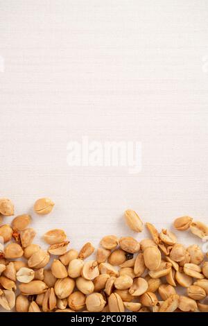 Spicy flavored peanut kernel spilling on white table background. Stock Photo