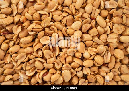 Spicy flavored peanut kernel spilling on white table background. Stock Photo