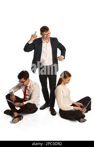 Emotional young people, businessmen, co-workers sitting and discuss new project, studying isolated over white background. Teamwork, business process Stock Photo