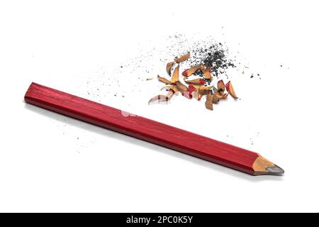 Red wooden carpenter's pencil sharpened with knife. Close up with shavings and bits of graphite. Stock Photo