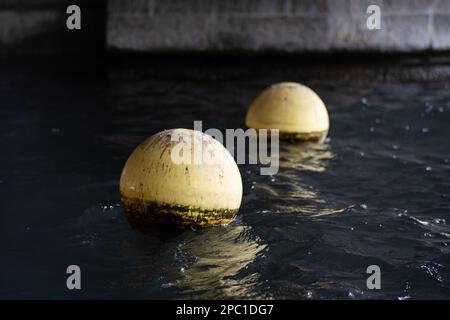 Yellow plastic buoy or buoys floating on a lake water in Switzerland, Europe. Close up telephoto shot, no people Stock Photo