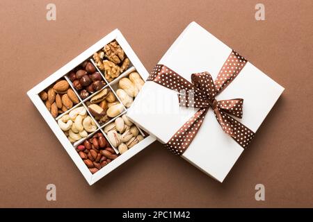 Various varieties of nuts lying in paper box on table background. Top view. Healthy food. Close up, copy space, top view, flat lay. Walnut, pistachios Stock Photo