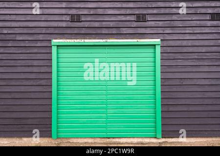 Wooden green door on a black barn building. Stock Photo