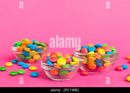 Multicolored candies in a bowl on a colored background. birthday and holiday concept. Top view with copy space. Stock Photo