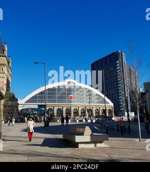 10th March 2023 - Liverpool Lime STreet station with a woman in red in the foreground echoing the colour of the station logo. Stock Photo
