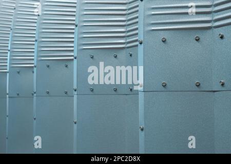 Metal sheets in light blue and green with folds and nuts protect exterior. Stock Photo