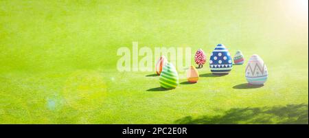 Easter eggs on green grass with sunlight, panoramic banner with copy space, Happy easter celebration concept Stock Photo