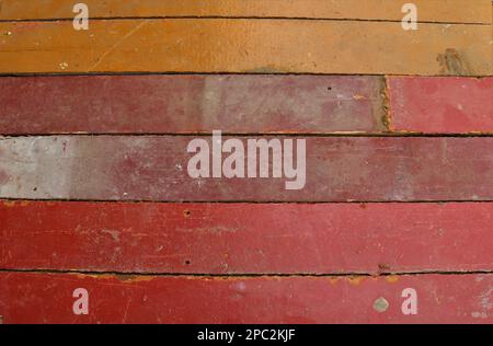 uneven plank surface painted in red and brown shades as an empty texture, a fragment of wooden planks dilapidated from time to time Stock Photo