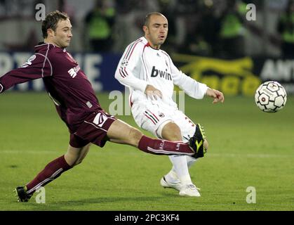 Arezzo s Fabio Roselli left goes for the ball as AC Milan s