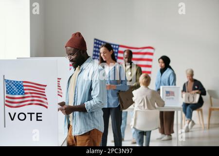 Voters stand in a queue at a polling booth during the first phase of ...
