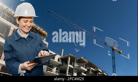 Woman with a digital tablet controls a remote-controlled unmanned crane. Digital transformation in construction industry. Stock Photo