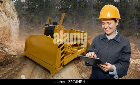 Engineer programs autonomous bulldozer using digital tablet Stock Photo