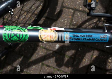 environment and climate change related stickers on a parked bicycle  including those for extinction rebellion and pedal on parliament Stock Photo