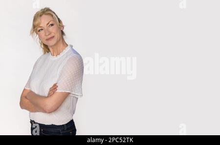 Attractive happy smiling female middle aged woman looking up in a studio portrait on white background Stock Photo