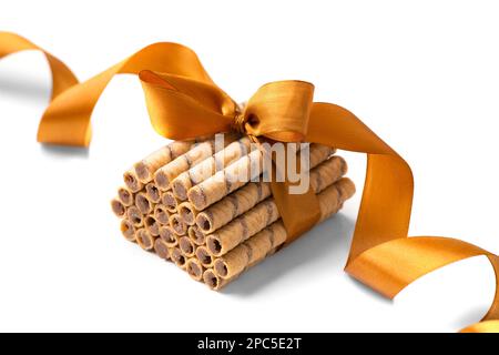 Wafer rolls with chocolate isolated on white background. Wafer rolls on a white background. Wafers tied with tape on insulation. Crispy dessert. Stock Photo
