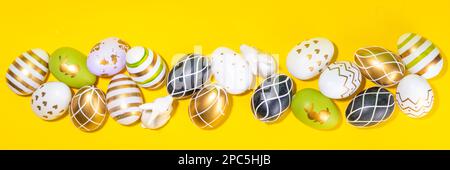 Bright Easter greeting card background. Trendy colored black, golden, stripe painted Easter eggs with white bunny rabbits decor, tulip flower on high- Stock Photo
