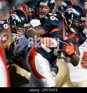 Tennessee Titans Keith Bulluck (53) attempts to tackle Denver Broncos  running back Tatum Bell (26) at Invesco Field at Mile High in Denver,  Colorado, Saturday, August 19, 2006, in NFL preseason action. (