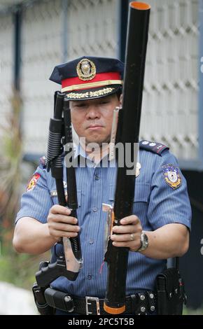 A Philippine police officer looks at a broken toy cannon made of hard  plastic water pipes, locally known as Boga, at the Southern Police  District Headquarters in suburban Manila, Friday, Dec. 29