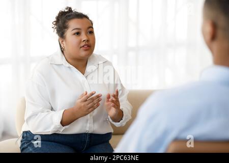 Pretty young mixed race woman plus size visiting psychologist Stock Photo