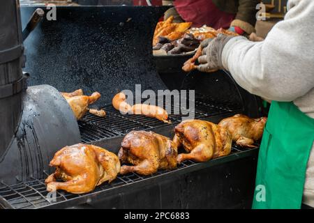 Smoking chicken and sausages in a smoker in Kaziuko Muge or Saint Casimir's Fair, a spring annual folk arts and crafts fair in Vilnius, Lithuania, Eur Stock Photo