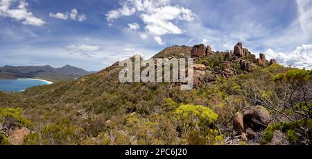 Panorama of the rocky outcrops on The Hazards in Freycinet National park, with Wineglass bay, Mount Graham and Mount Freycinet in the distance. Summer Stock Photo