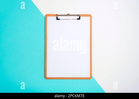 Clipboard with blank paper on blue and white background. Top view, flat lay, mockup. Stock Photo