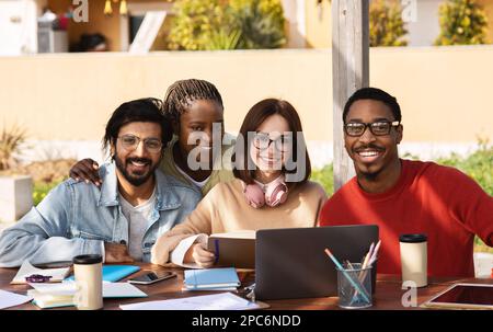 Happy millennial different people students studying with laptop together, working on project remotely Stock Photo