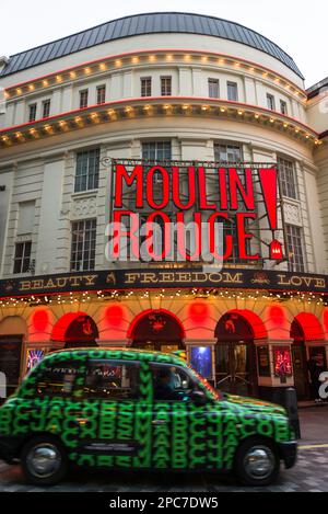 London cab passing by Moulin Rouge musical at the Piccadilly Theatre, Soho, London, England, UK Stock Photo