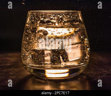 Glass with water and ice cubes on a black background Stock Photo