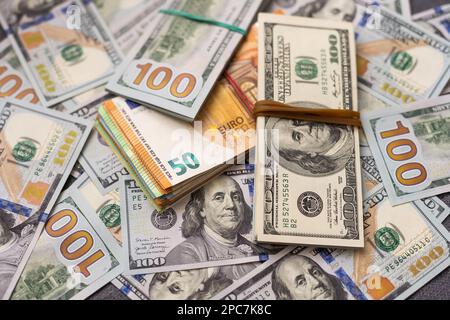 200 Euro banknote next to 50 euros on top of one hundred dollar bills. Trading Euro with Dollar Stock Photo