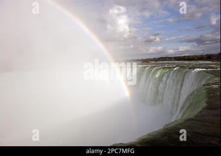 Rainbow forming in spray over waterfall, Horseshoe Falls, Niagara Falls, Niagara River, Ontario, Canada Stock Photo