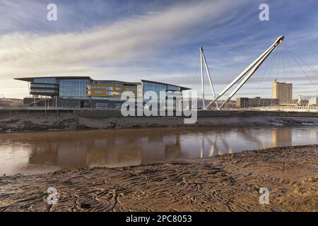 View of tidal river, waterfront building and footbridge, Newport University, Newport City Footbridge, River Usk, Newport, South Wales, Wales Stock Photo