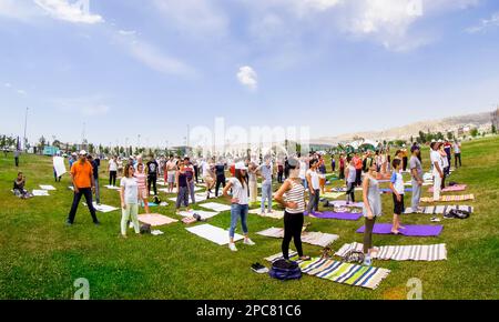 Baku, Azerbaijan, may 20, 2019: men and women practice yoga in a Park on a green glade Stock Photo