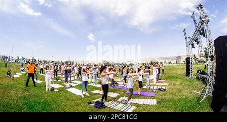 Baku, Azerbaijan, may 20, 2019: men and women practice yoga in a Park on a green glade Stock Photo