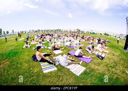 Baku, Azerbaijan, may 20, 2019: men and women practice yoga in a Park on a green glade Stock Photo