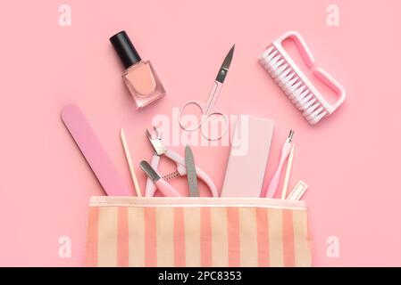 Top view of manicure bag with cosmetics and accessories for manicure or pedicure over pink background. Manicure and pedicure concept Stock Photo