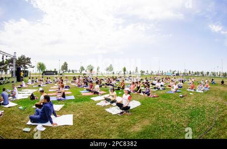 Baku, Azerbaijan, may 20, 2019: men and women practice yoga in a Park on a green glade. Stock Photo