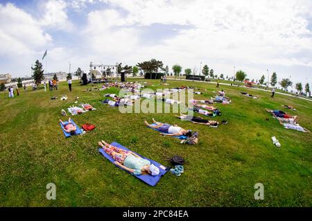 Baku, Azerbaijan, may 20, 2019: men and women practice yoga in a Park on a green glade. Stock Photo