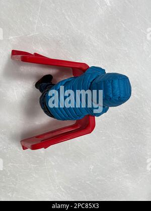 Beginner ice skater using a plastic walker for assistance. Stock Photo