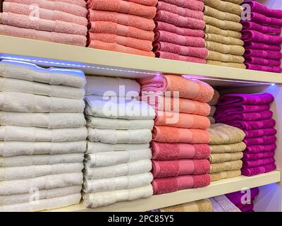 Multicolor towels on shelf in market, sale cotton towels, stack colored cotton towels, a shelf in the home row of the market, close-up selective focus Stock Photo