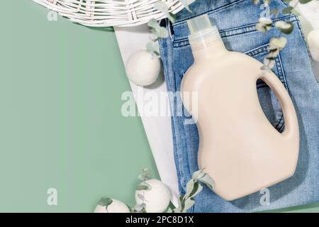 Natural laundry detergent mockup. Washing detergent concept with bottle of washing gel or fabric softener on clothes with laundry balls and eucalyptus Stock Photo