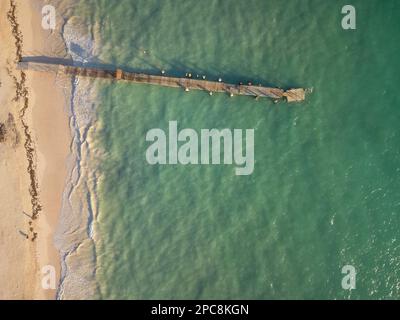 Wooden pier on the sea. White sandy beach. There is no one in the photo. Romance, solitude, sports, fishing, ecology, climate, environmental protectio Stock Photo