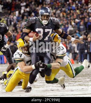 Seattle Seahawks' Shaun Alexander is brought down on a first half run by Green  Bay Packers' Abdul Hodge (55) and Kabeer Gbaja-Biamila in the first half of  a football game Monday, Nov.