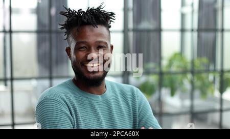 a confident black guy in a green jacket close-up. Stock Photo