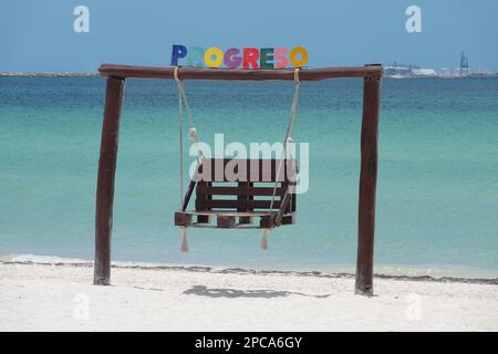 View of swing made of wood with colorful sign on the beach of progreso near the longest pier in the world in Progreso, near Merida, Yucatan Mexico- Stock Photo