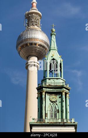 Berlin GERMANY 24-03-2020 Copper top of Baroque and Neo-Gothic tower of St. Mary's Church (Ger: Marienkirche), with Fernsehturm Berlin (Eng:TV Tower) Stock Photo