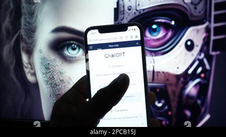 Mobile phone with Chat GPT-4 website artificial intelligence company OpenAI LLC on screen in front of half human half android face. Stock Photo